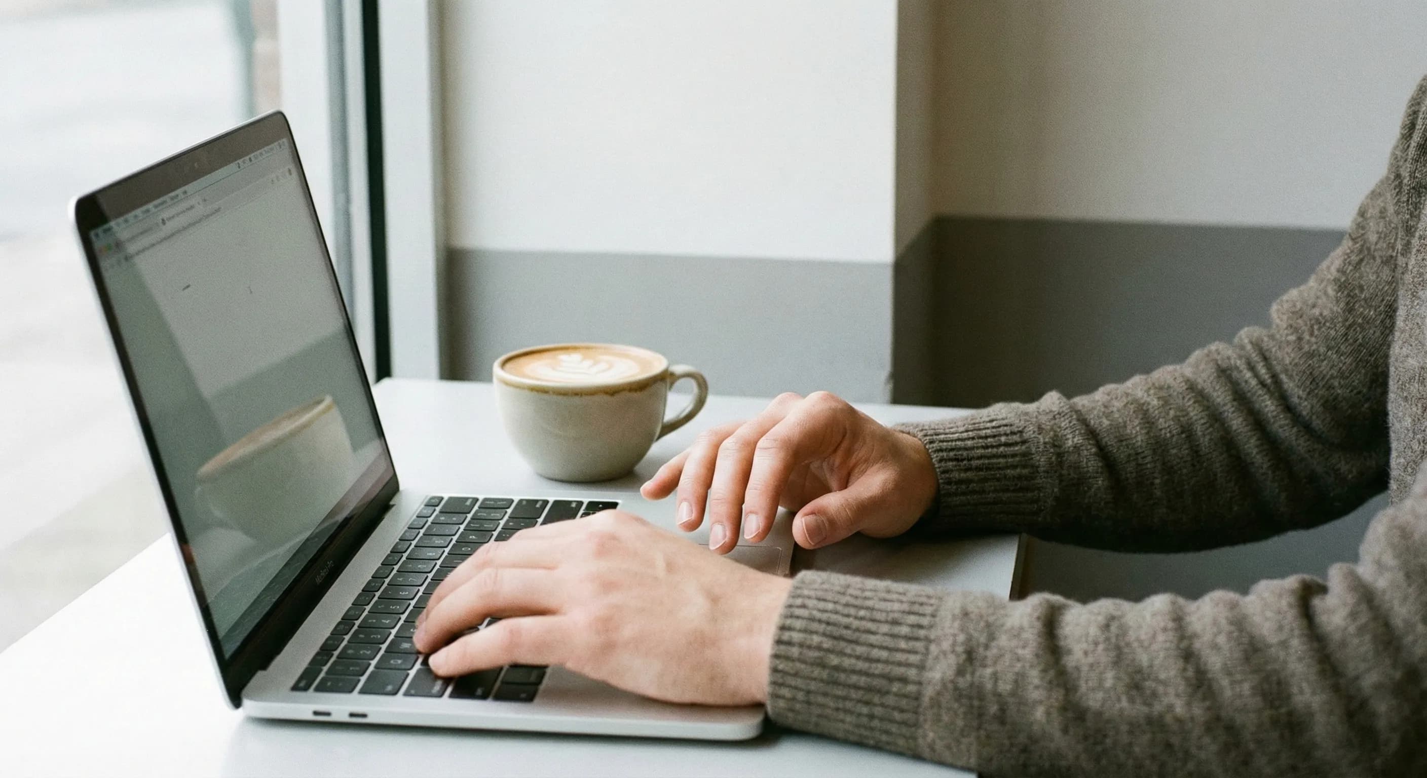 カフェでPCを開く男性の手元